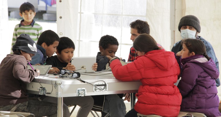 Picture of children using the tablets of the Ideas Box at the Eleonas refugee camp in Athens