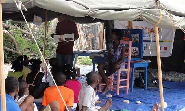 Photo de déplacés dans une tente avec des livres à Port-au-Prince