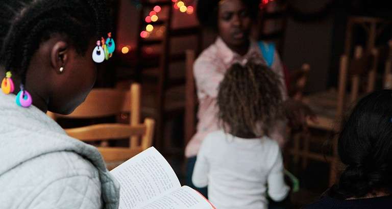 Photo d'une jeune fille qui lit dans un hôtel du Samu Social