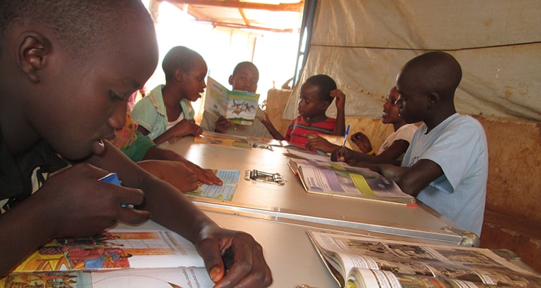 Photo d'enfants réfugiés lisant des livres de l'Ideas Box au Burundi