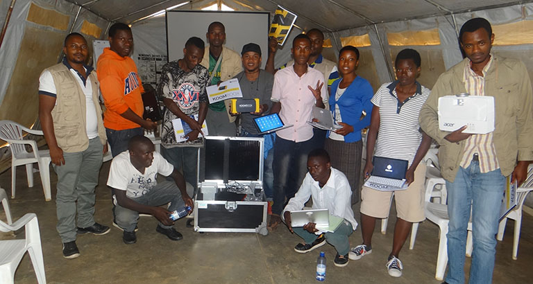 Photo des jeunes réfugiés congolais et de l'équipe d'EYE posant avec le KoomBook