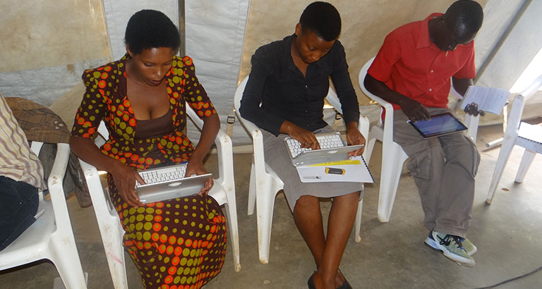 Photo de femmes réfugiées au Rwanda utilisant les tablettes du kit KoomBook