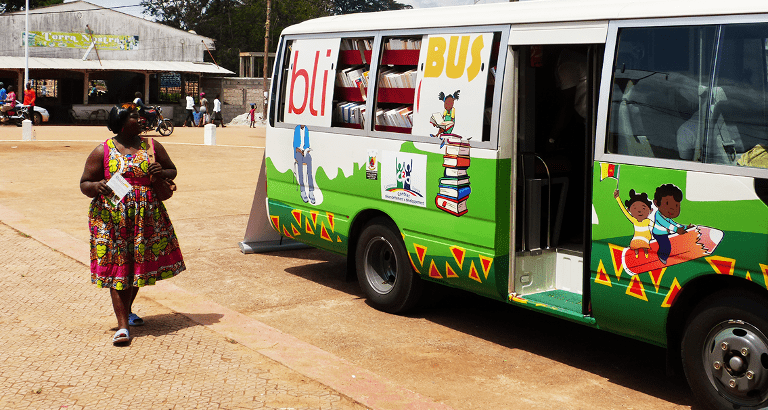 Photo d'une femme passant devant le bibliobus à Yaoundé