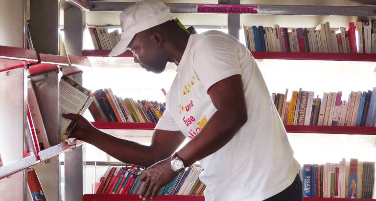 Photo d'un animateur rangeant un livre dans le bibliobus à Yaoundé