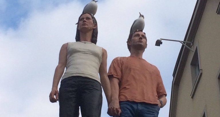 Photo d'une statue de couple avec des oiseaux sur la tête à Düsseldorf
