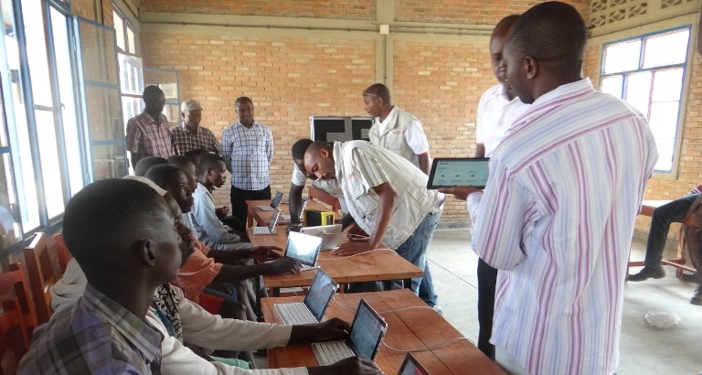 Photo des mineurs du centre de Rumonge assis devant les tablettes du kit KoomBook