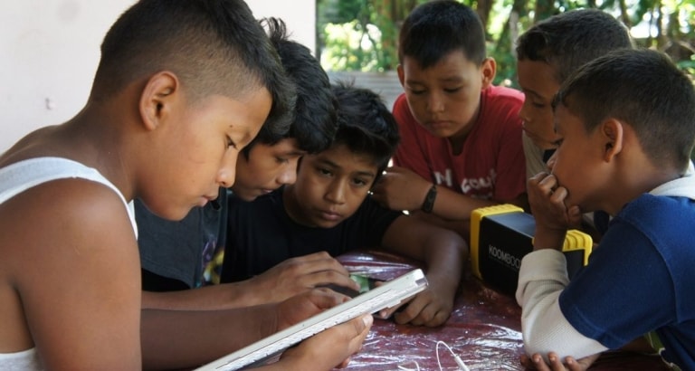 Photo de garçons accédant aux contenus du KoomBook avec une tablette au Nicaragua