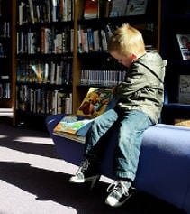 Photo d'un enfant lisant un livre à la bibliothèque