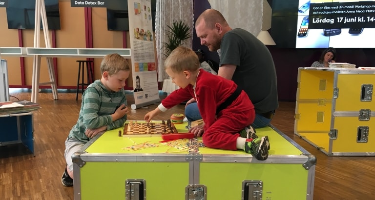 Photo d'un père et son fils jouant aux échecs sur l'Ideas Box à Stockholm