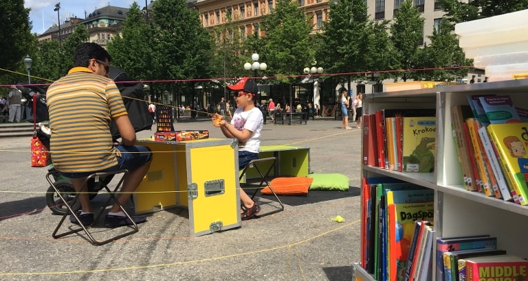 Photo d'un père et son fils jouant au puissance 4 sur l'Ideas Box à Stockholm