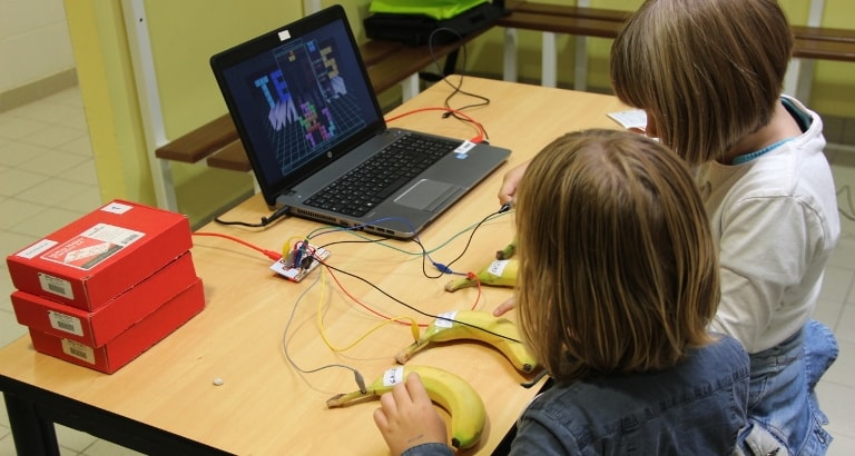 Photo de deux jeunes filles qui jouent au Tétris pendant l'atelier de Makey-Makey