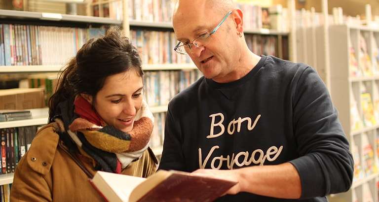 Photo de deux personnes lisant un livre