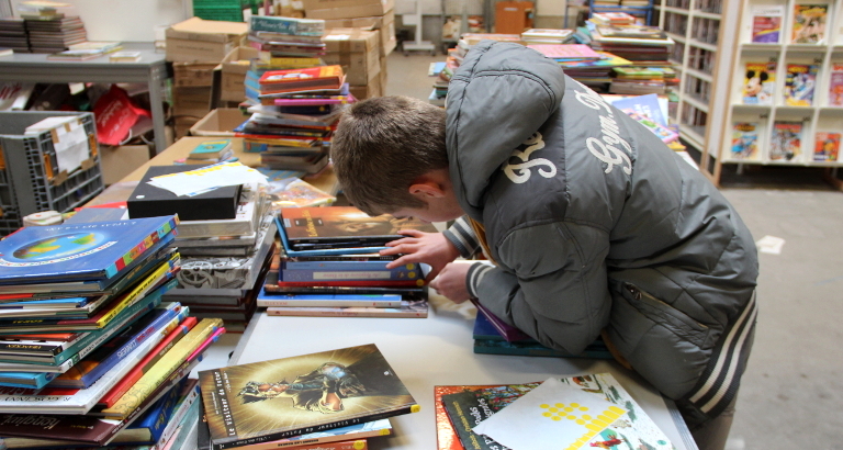 Photo de Noé qui pastille les livres pour la braderie de Noël d'Epône