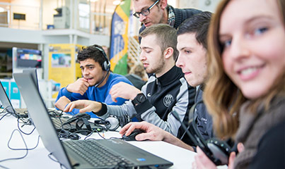 Jeunes devant ordinateurs, en formation, souriant